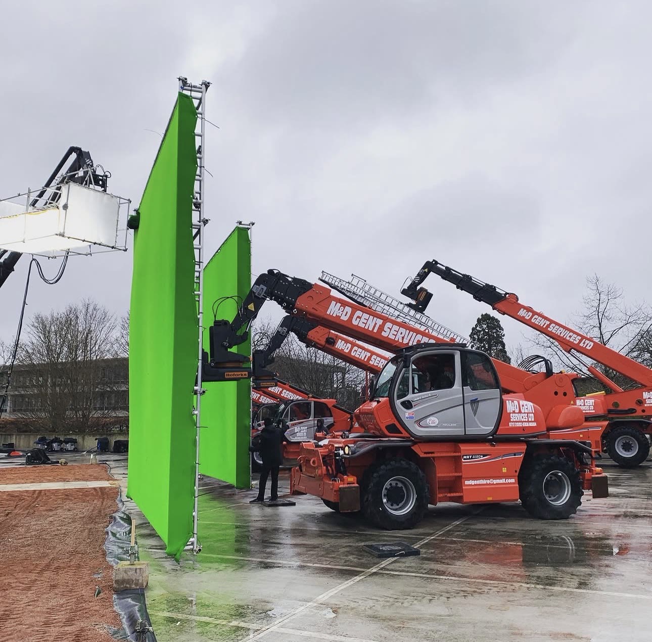 Greenscreen backings rigged on telehandlers